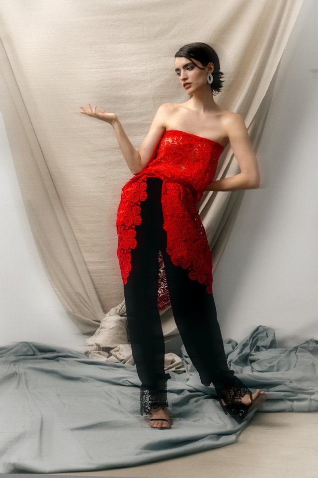 Modelo con encaje rojo sobre pantalón negro